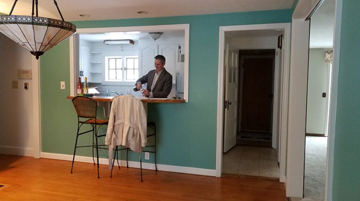 Pass-through window to a kitchen from a green dining room wall