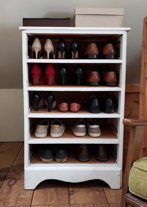 Cabinet with 5 narrow shelves holding shoes